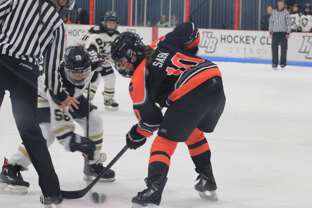 Claire S. (#10) lines up the faceoff with the ref.