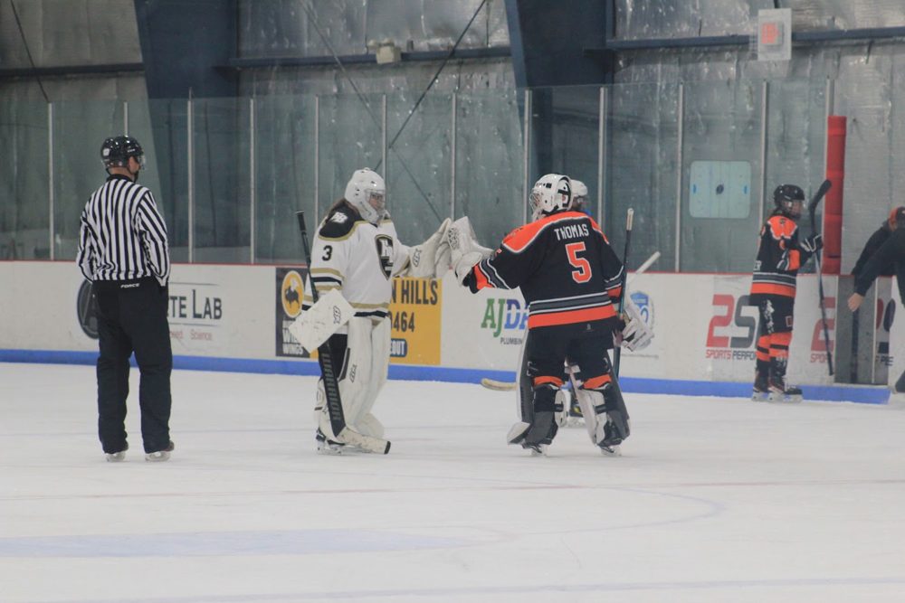 Makayla T. (#5) and HB's goalie share a glove tap.