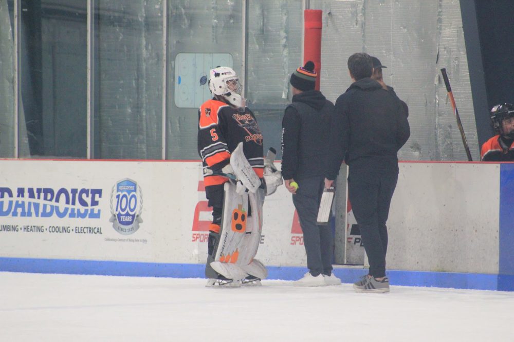 Our goalie, Makayla T. (#5), gets instructions at the boards.