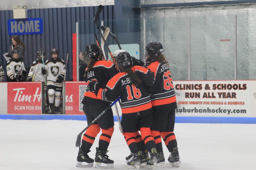 Huddle by the bench: Kaylee M. (#16) and teammates.