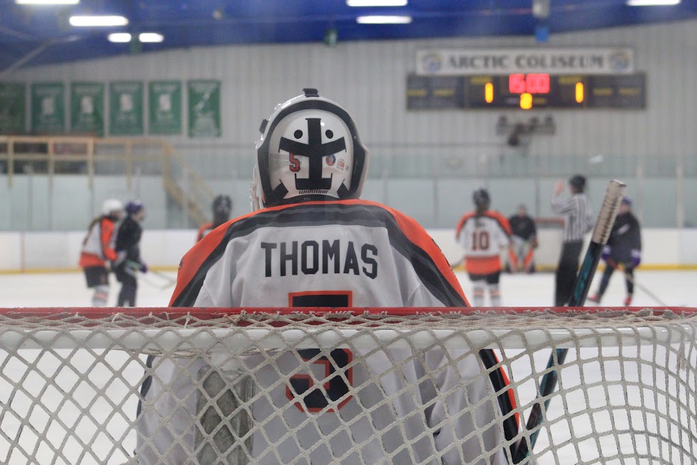 Makayla T. (#5) locked in between the pipes, Claire S. (#10) on the play behind her.